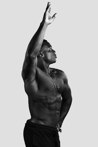 Midsection of shirtless man against white background