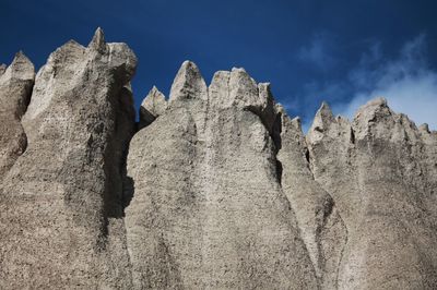 Low angle view of rocks on mountain against sky