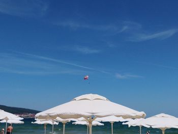 White umbrella on beach against blue sky