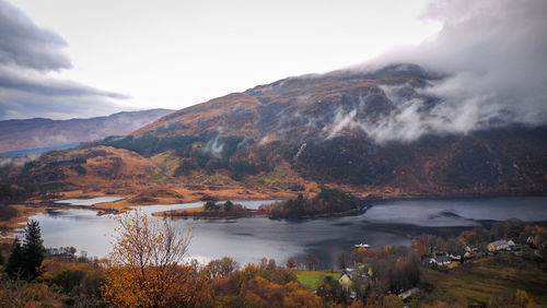 Scenic view of lake by mountains against sky