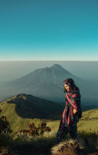 Man standing on mountain against sky