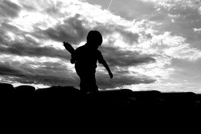 Silhouette woman standing against sky during sunset