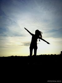 Silhouette woman standing on field against sky during sunset