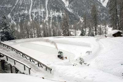 An ice skating piste and ice skating machine cleaning the snow in the alps switzerland in winter