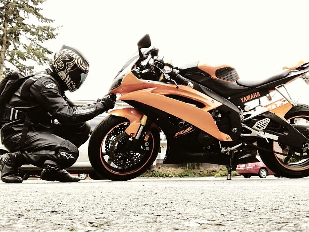 MAN RIDING MOTORCYCLE ON ROAD AGAINST THE SKY