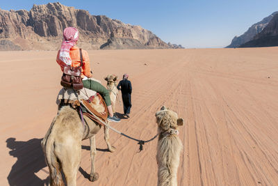 Rear view of man riding horse