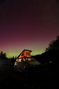 Cars on road against sky at night