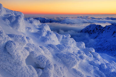 Scenic view of snow covered landscape against sky during sunset