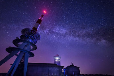 Low angle view of illuminated building against sky at night