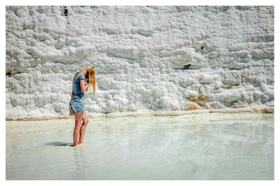 Full length of woman standing in water