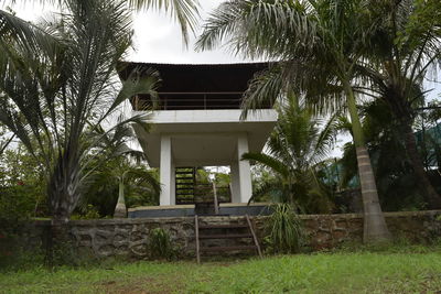 Gazebo by palm trees against sky