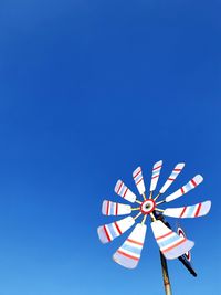 Low angle view of ferris wheel against clear blue sky