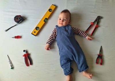 Flat lay of cute baby with mechanic tools