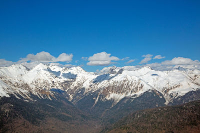 Scenic view of snowcapped mountains against blue sky