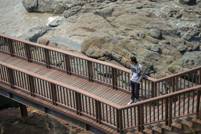 Side view of woman standing on rock