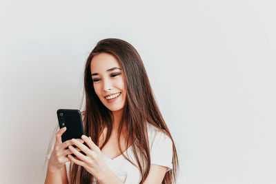 Portrait of smiling young woman using smart phone