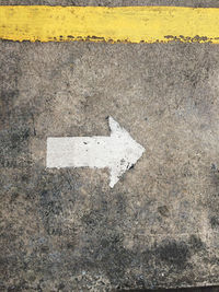 Arrow sign on asphalt surface