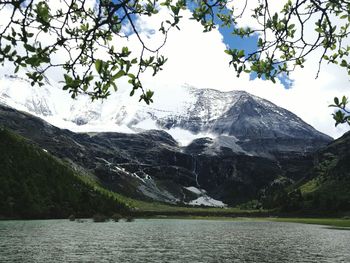 Scenic view of lake by mountains against sky