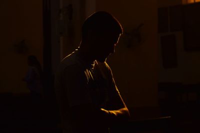 Close-up of man looking away against black background