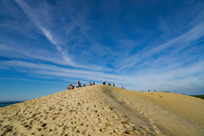 People on desert against sky