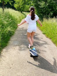 Rear view of girl  longboard skating