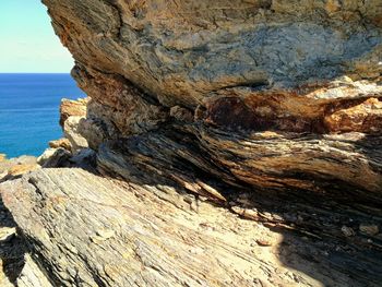 Close-up of rock formation by sea against sky