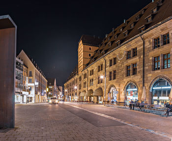 Street amidst buildings in city at night