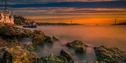 Scenic view of bay against sky during sunset