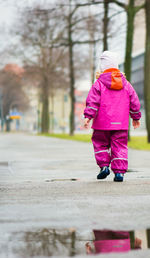 Rear view of woman walking on footpath