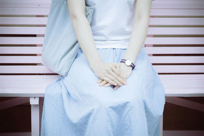 Midsection of woman sitting on seat