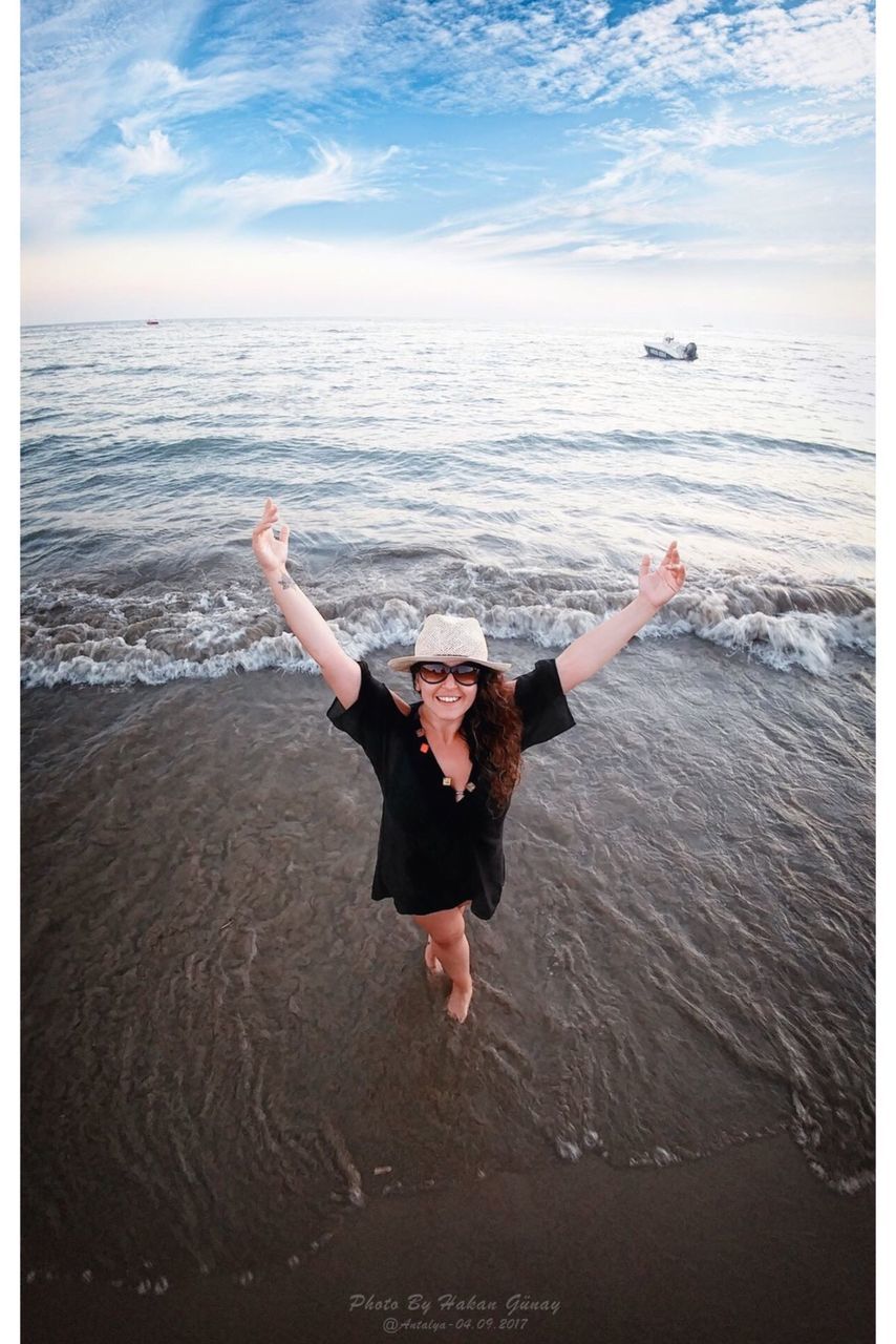 sea, water, one person, human arm, limb, leisure activity, land, full length, beach, nature, motion, horizon, lifestyles, enjoyment, horizon over water, holiday, real people, vacations, arms raised, arms outstretched, outdoors, freedom