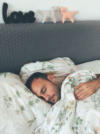 High angle view of young man sleeping on bed at home