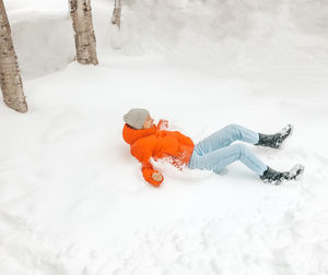 Person lying on snow covered land