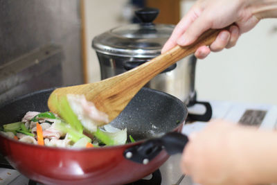 Midsection of person preparing food in kitchen at home