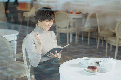 Woman reading diary while sitting at cafe
