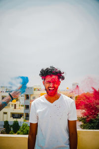 Portrait of smiling young man standing against sky