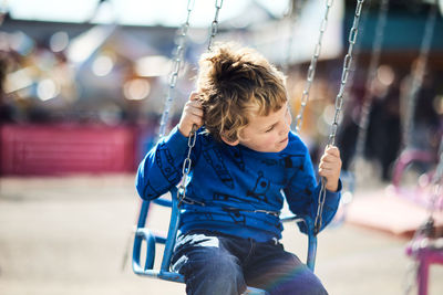 Boy swinging at playground