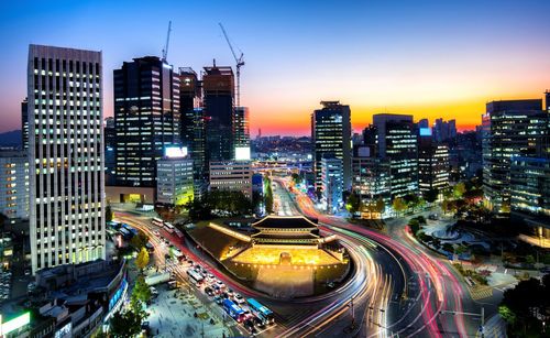 High angle view of illuminated street amidst buildings at night