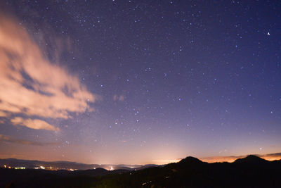 Scenic view of silhouette mountains against sky at night