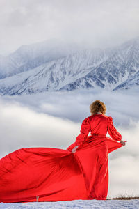 Portrait of woman standing on snowcapped mountain