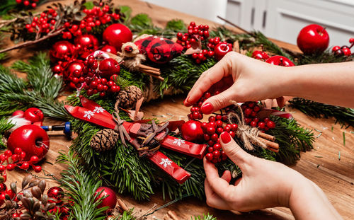 Cropped hands of woman holding christmas tree