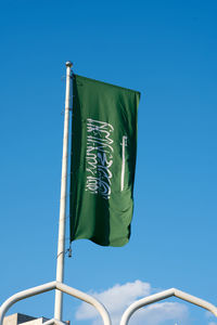 Low angle view of flag against blue sky