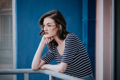 Woman looking away while standing in balcony