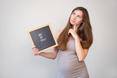 Portrait of young woman using digital tablet against white background