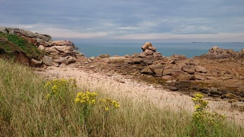 Rock formations by sea against sky