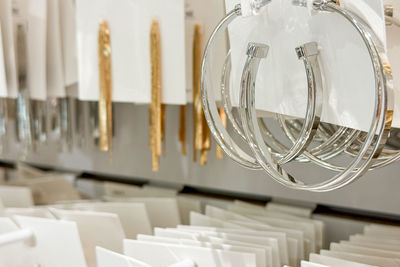 A close-up display of hoop earrings and long gold earrings arranged on a jewelry rack 