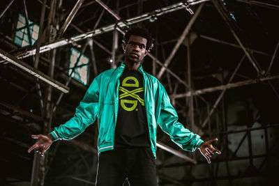 Portrait of young man standing against ceiling