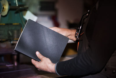 Midsection of man using digital tablet