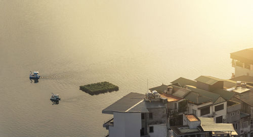 High angle view of houses by sea against sky