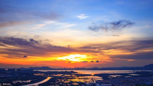 Aerial view of city against sky during sunset